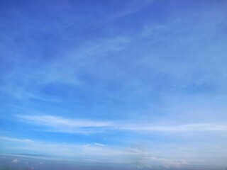 Panoramic vibrant blue sky with soft white wispy cirrus clouds. Perfect for nature background, weather-related designs, or as a copy space area for creative projects