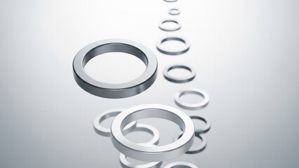A collection of silver rings of various sizes floating in mid-air against a gradient background