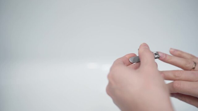 Cutting nails on a man's hand with nail tongs on a white background. Care for hands.