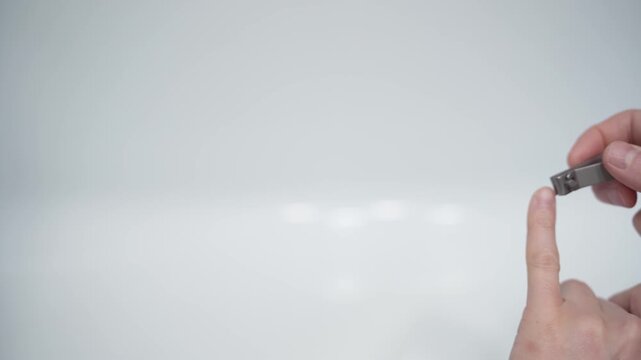 Cutting nails on a man's hand with nail tongs on a white background. Care for hands.