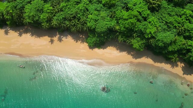 Aerial view of the magnificent Monkey Beach on Ilha do Pr&iacute;ncipe.A deserted beach with a boat anchored in the turquoise sea and the beautiful forest surrounding it.S&atilde;o Tom&eacute;,Africa