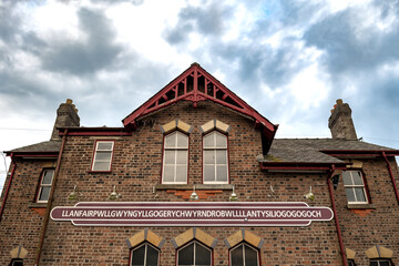 Name Plate On Trainstation Building Of Villag Llanfairpwllgwyngyllgogerychwyrndrobwllllantysiliogogogoch in Wales, UK