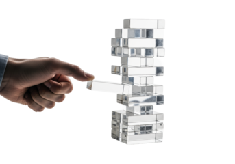 caucasian hand precisely removing a clear, reflective acrylic block from an unstable jenga tower, shot macro on a high-key white background with copy space. concept of calculated risk