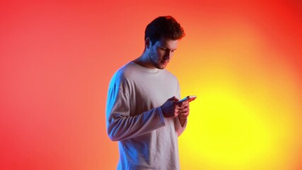 Young man using smartphone rotating against colorful gradient studio background. Concept of mobile technology promotion, digital communication, app interface presentation, and modern lifestyle content