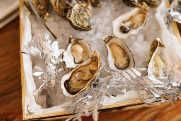 Fresh opened oysters served on ice in a wooden box
