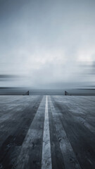 A wooden pier extends towards a foggy, overcast sky over the water.