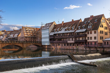 Die Maxbr&uuml;cke &uuml;berspannt die Pegnitz in der N&uuml;rnberger Altstadt. Am Ufer stehen historische Fachwerkh&auml;user mit schneebedeckten D&auml;chern. 