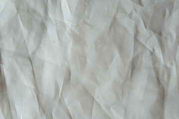 Soft neutral plastic texture with small dot pattern and chaotic folds, abstract modern background for creative projects.