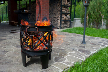 The male hand and warm fireplace with lots of trees ready for barbecue