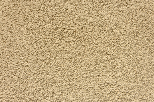 Beige stucco wall with rough texture. Plastered surface background.