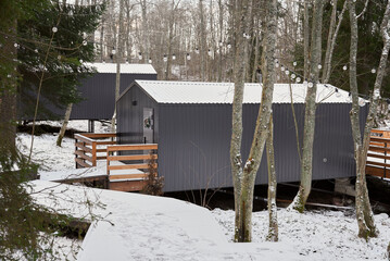 Stylish lodges connected by walking path in snowy landscape
