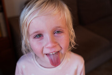 Portrait of a child showing mixed emotions: upset and crying but goofing around after a tantrum.