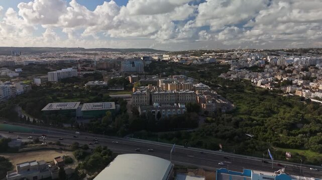 Aerial view of the university and Mater Dei Hospital buildings in Msida, Malta, showcasing urban design and Mediterranean architecture under a cloudy winter sky.