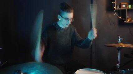 Percussionist practicing with lively motions and vibrant lighting