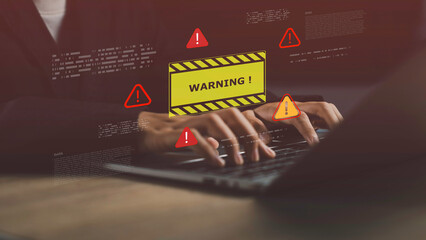 Laptop screen showing system warning alert with exclamation icons, symbolizing digital threats, security risk, hacking, virus attacks, and data breach in a coding environment.