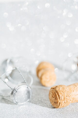Creative minimal style composition made of champagne corks on a shiny silver background. Bottle caps from sparkling wine and a metal wire muselet. Celebration and  party drink concept
