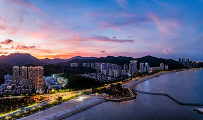 Aerial view of the modern coastal city with beach and skyline at sunset in Zhuhai.