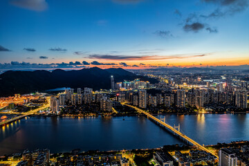 Fototapeta premium Spectacular aerial view of the modern city skyline and bridge over the river at sunset in Zhuhai.