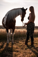 Junge Frau mit Pferd im Abendlicht. Sonnenuntergang auf dem Land mit Tieren © fuchs mit foto