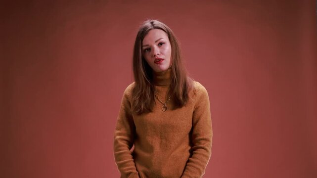 Disappointed woman openly showing frustration on brown background. Concept of negative reactions, audience responses, communication visuals, and expressive human emotion for commercial and digital use