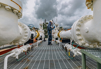 Male worker inspection at steel long pipes and pipe elbow in station oil factory during refinery valve of visual check record pipeline tank oil