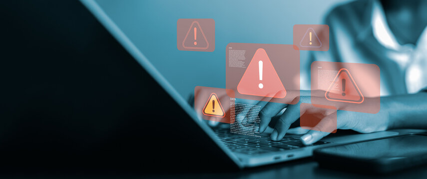 A person using a laptop with multiple red warning sign popups, symbolizing cyber security threats, system error, data breach, and hacking vulnerability in digital business technology concept. - Powered by Adobe