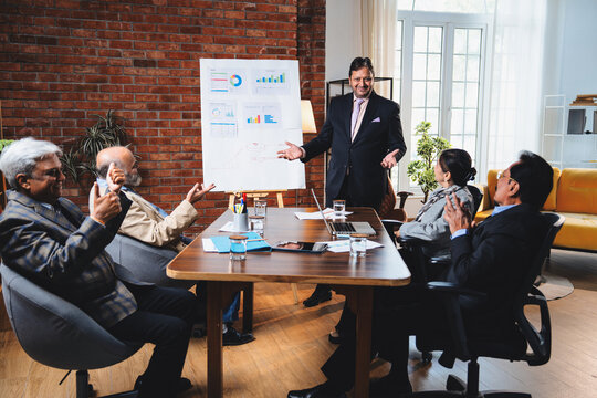 Senior Indian Asian business leaders discussing growth projection, strategy in modern office meeting
