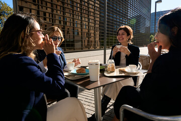 Business women enjoying outdoor coffee break together