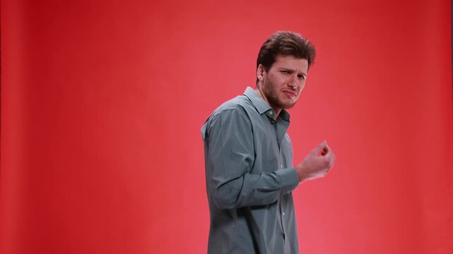 Disgusted man reacting with visible aversion on red background. Concept of failed checkout reactions, complaint handling visuals, content moderation scenes, and social awareness messaging.