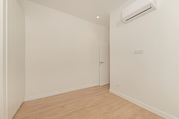 Empty corner room, showing how custom white built-in wardrobes make the most of the space under a sloping ceiling, creating clean lines and a seamless look