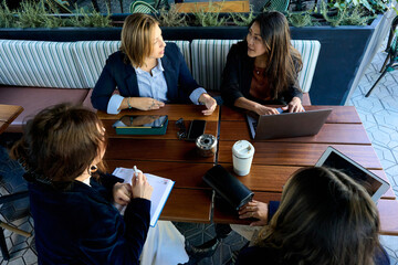 Women discussing business ideas at a cafe