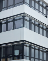 Fototapeta premium Modern architecture featuring sleek glass windows and clean lines on a city building facade during daytime