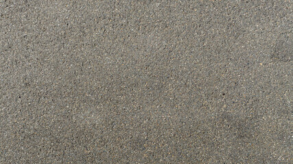 Aerial close-up shot of a uniform, grainy grey surface. Ideal for texture, pattern and background of paved road. Closeup of asphalt and street. © Stefano Tammaro