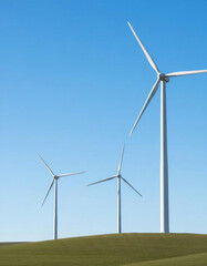 Fototapeta premium Wind turbines stand on green hills under blue sky