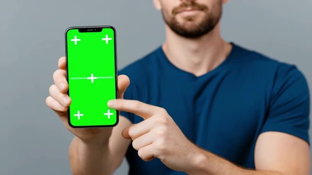 Young man hand hold cell phone, green screen mock up. Mobile smartphone chroma key template. Cellphone display close up. Business mockup empty blank space. Modern gadget