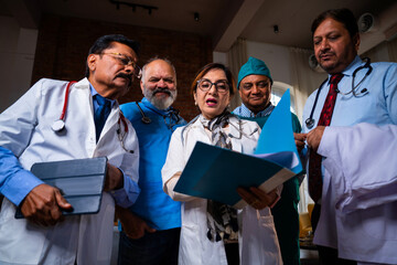 Indian senior surgeons and doctors analyzing medical case file before surgery
