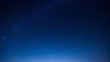 A serene night sky with a subtle gradient of deep blues and a hint of light on the horizon