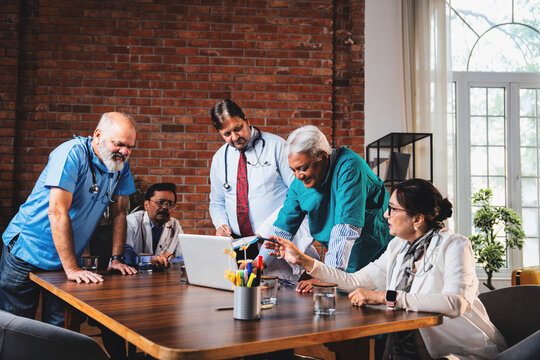 Senior Indian doctors and surgeons analyzing patient data on laptop to plan treatment - Powered by Adobe