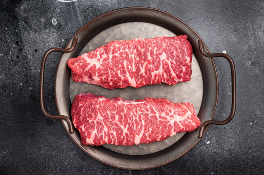 Premium denver, chuck eye steak, beautifully presented, ready for seasoning. A versatile cut ideal for barbecue enthusiasts and steak lovers alike. black background. top view