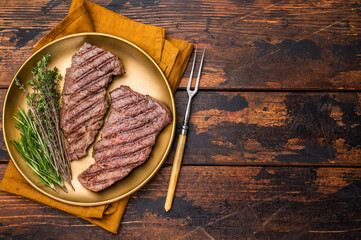 Juicy Denver, chuck eye steak, expertly grilled to perfection, offering a mouthwatering aroma and a deliciously charred exterior. wooden background. top view