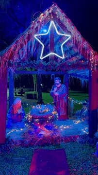 Illuminated Nativity scene at night. Christmas scene with figures representing the birth of the baby Jesus Christ in the manger.