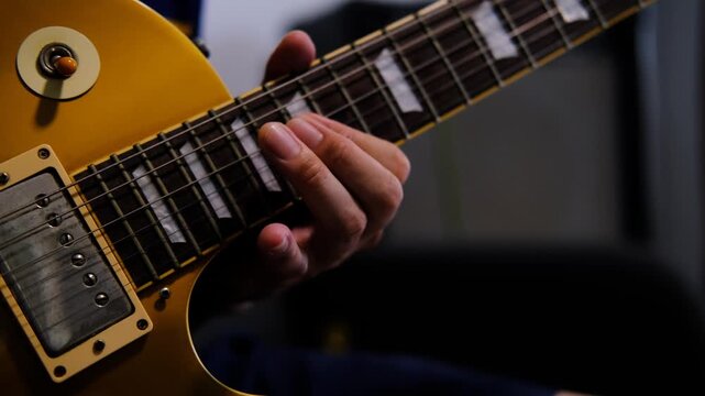 Close up guitarist hand playing electric guitar, Musician practice to play guitar solo in music practice room.