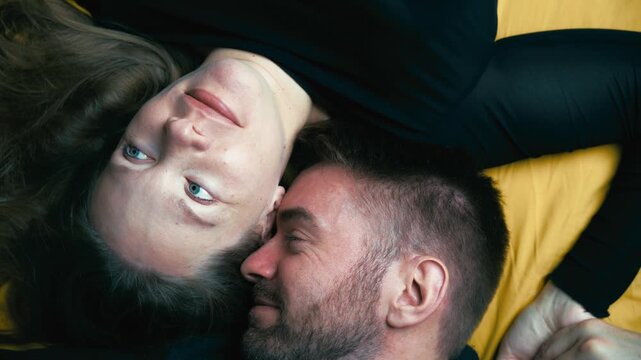 Romantic couple on bed showing love, intimacy and togetherness. Camera is rotating, top-down view, overhead shot. Suitable for valentine and project clarifying relationships, affection, connection.