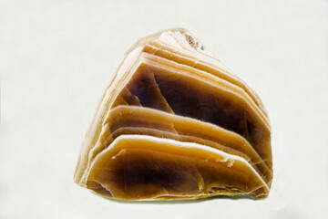 Brown marble onyx on a light background. Gems, mineralogy, jewelry.