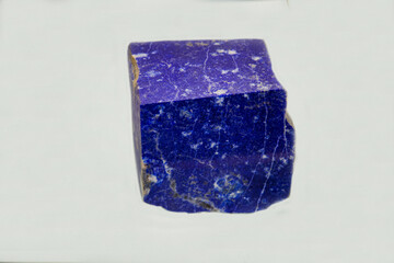 Lapis lazuli is blue in the shape of a square on a light background. Gems, mineralogy, jewelry.