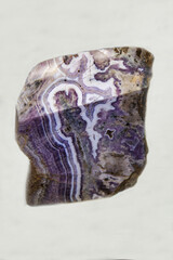 Lilac-colored amethyst on a light background. Gems, mineralogy, jewelry.