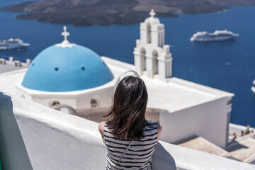 Woman Facing Blue Dome Church in Santorini, Greece