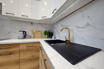 Kuchnia w apartamencie w jasnych kolorach , biel, brązowe fronty szafek, stolik śniadaniowy