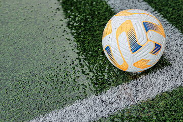 Close-up of a soccer ball on a wet artificial turf field