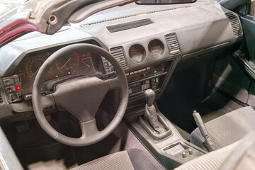 Interior view of a car showing dashboard and gear shift in a display setting during a car exhibit in the afternoon